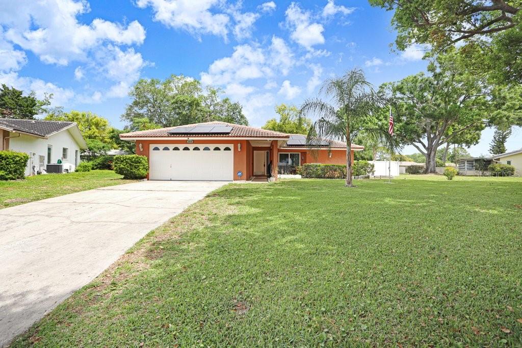 1632 Heather Place Palm Harbor, FL 34684 - Photo 6 of 53 a view of a house with a big yard and large trees