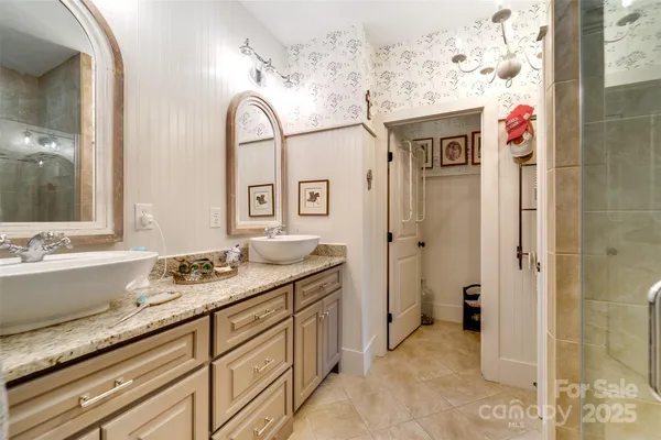 a bathroom with a granite countertop tub sink and mirror