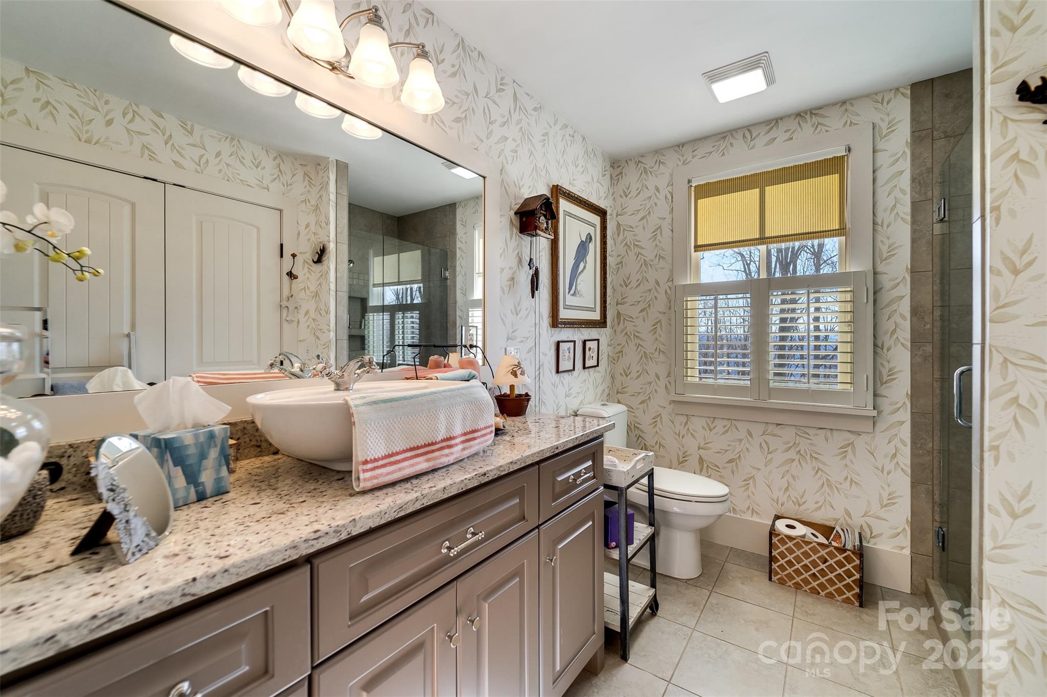 1226 Monteith Branch Road Sylva, NC 28779 - Photo 38 of 40 a bathroom with a granite countertop sink and a large mirror