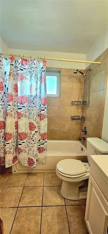a bathroom with a toilet and a shower curtain