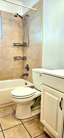 a white toilet sitting next to a bath tub and a shower