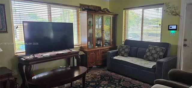 a living room with furniture a flat screen tv and a window