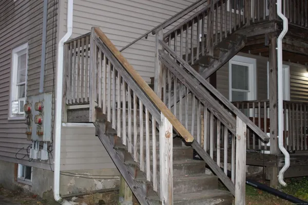 a view of staircase with lots of frames on wall and windows