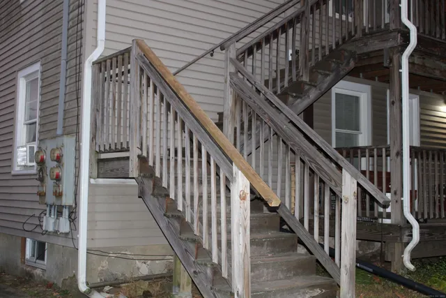 a view of staircase with lots of frames on wall and windows