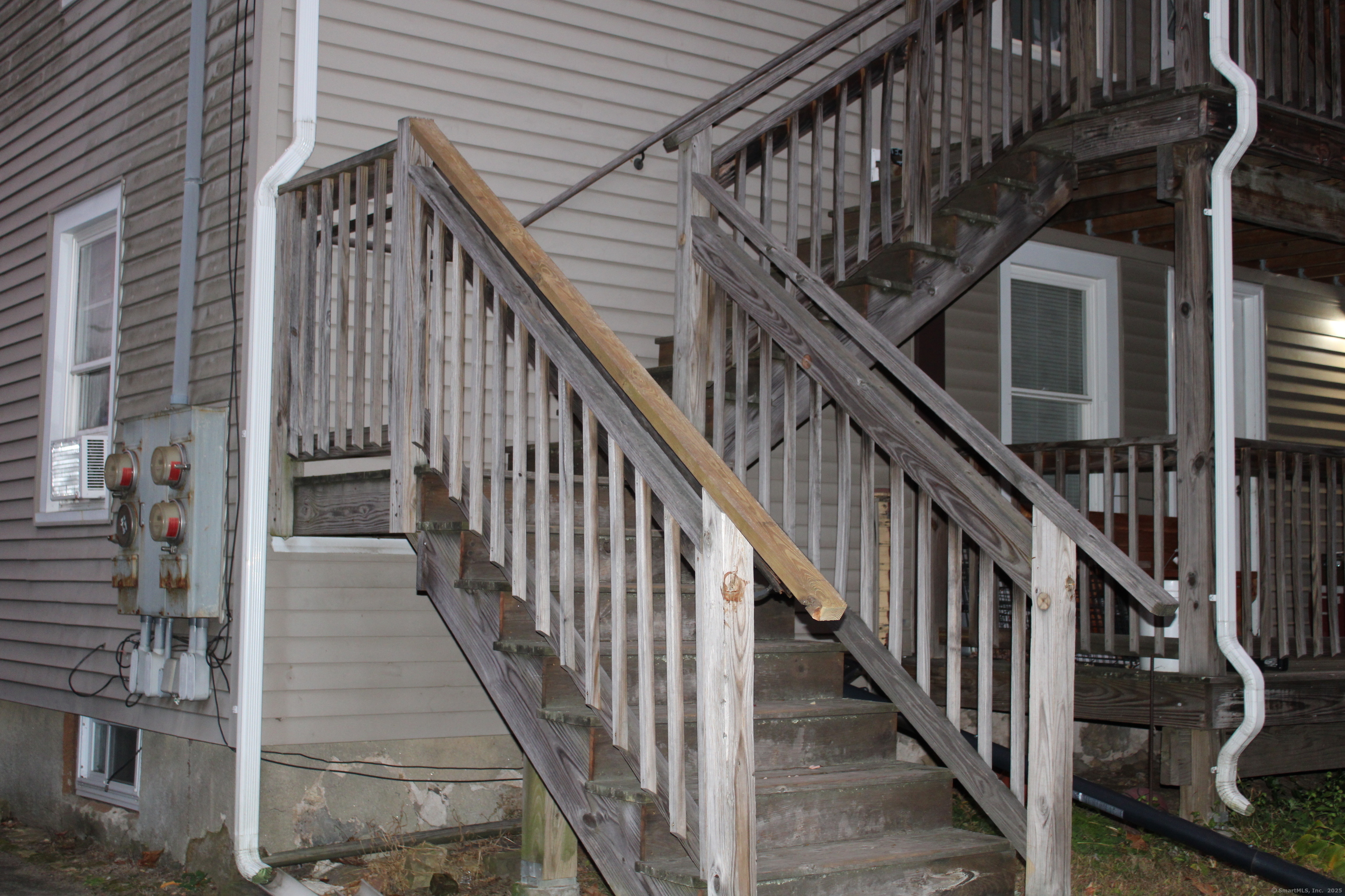 a view of staircase with lots of frames on wall and windows