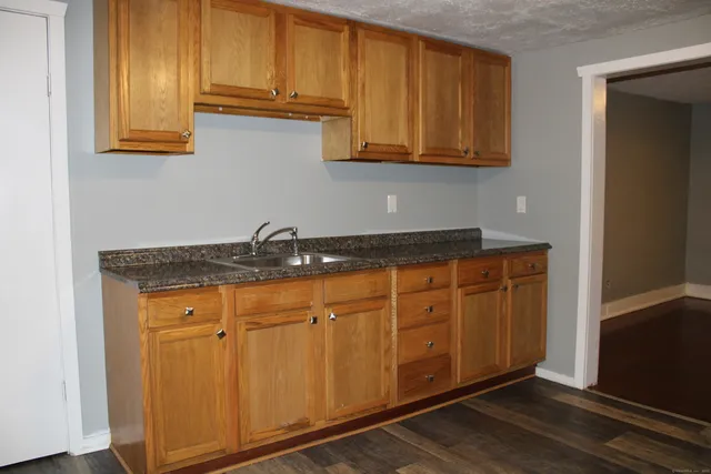 a kitchen with stainless steel appliances granite countertop a sink cabinets and a refrigerator