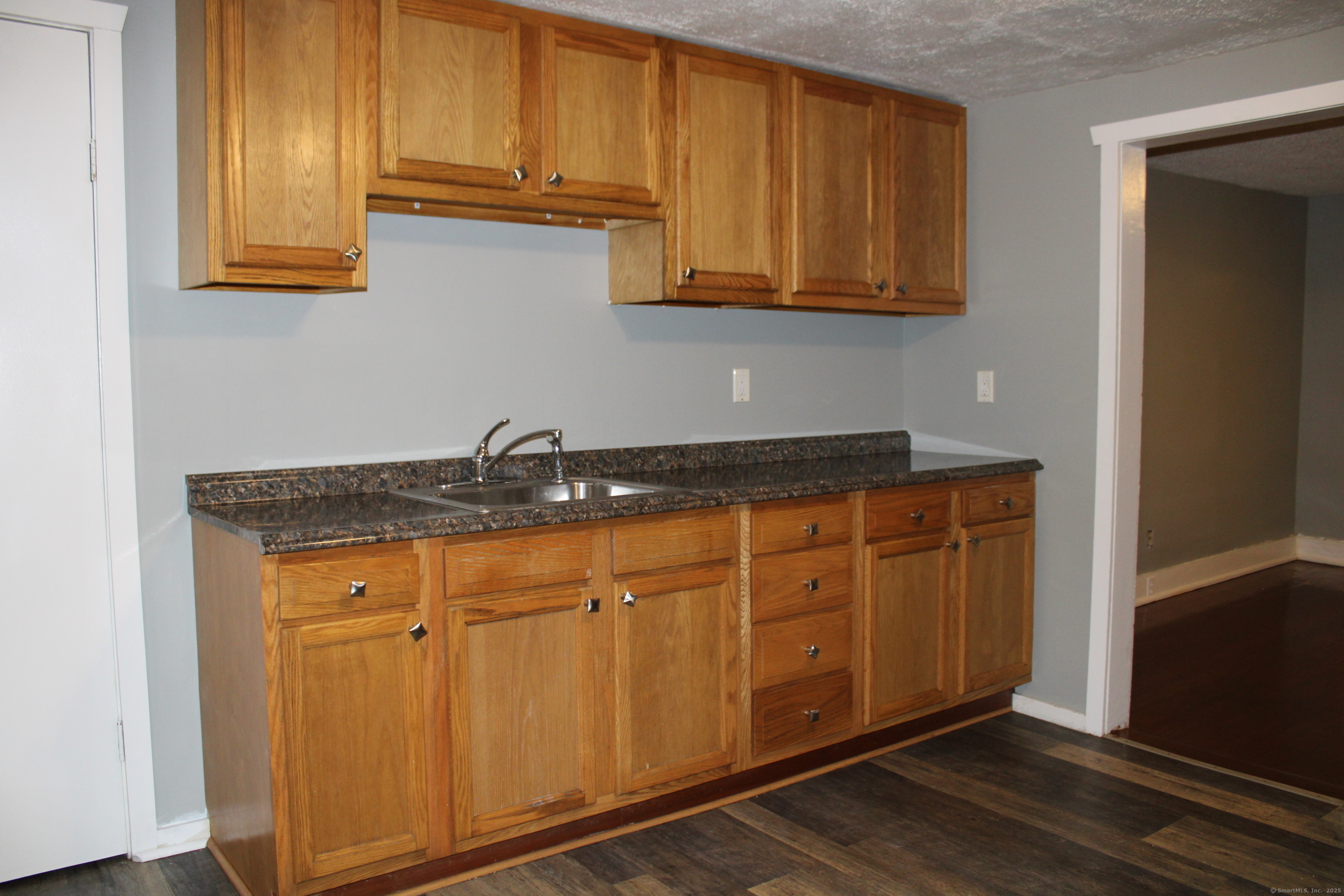 24 James Street Bristol, CT 06010 - Photo 7 of 12 a kitchen with stainless steel appliances granite countertop a sink cabinets and a refrigerator