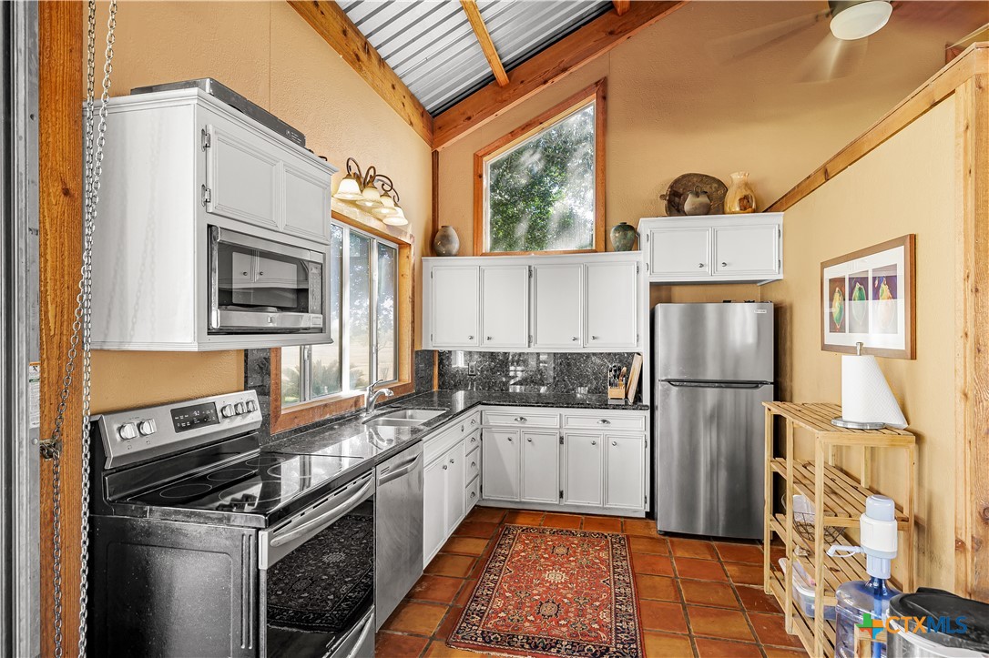 3052 Charco Road Nordheim, TX 78141 - Photo 11 of 43 a kitchen with a sink stove and refrigerator