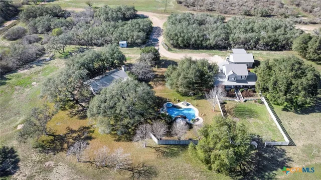 an aerial view of a house with a yard and lake view