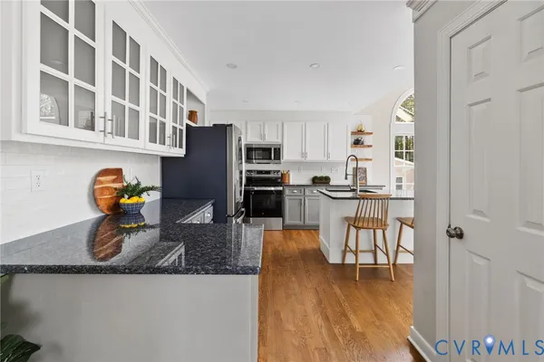 a kitchen with stainless steel appliances granite countertop a refrigerator a stove top oven a sink and dishwasher