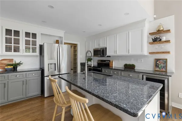 a kitchen with stainless steel appliances granite countertop a refrigerator sink and stove