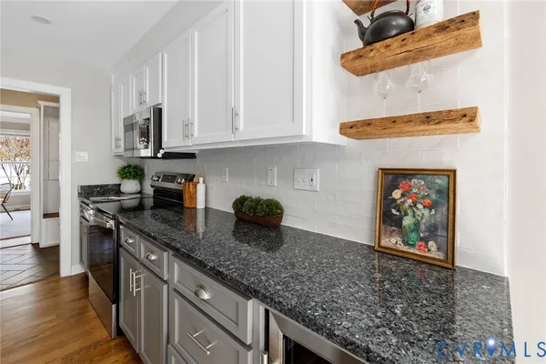 a kitchen with stainless steel appliances granite countertop a sink stove and cabinets