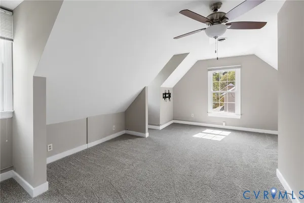 an empty room with a ceiling fan and window