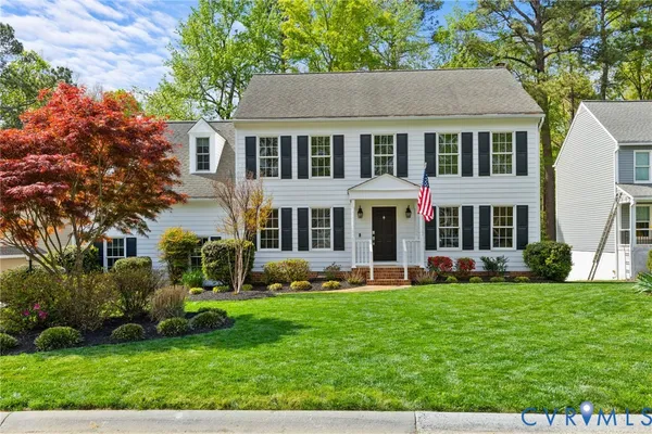 a front view of a house with a yard and trees