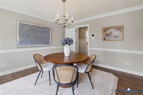 a view of a dining room with furniture a chandelier and wooden floor