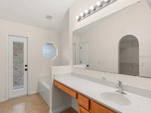 a bathroom with a sink a mirror and a bathtub