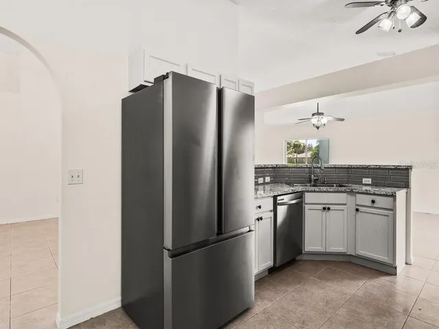 a kitchen with stainless steel appliances granite countertop a sink a refrigerator and a refrigerator