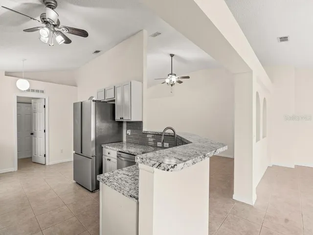 a kitchen with kitchen island a sink stainless steel appliances and cabinets