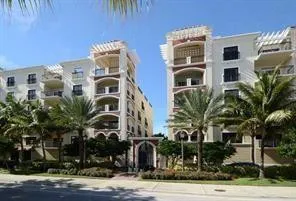 a front view of multi story residential apartment building with a yard