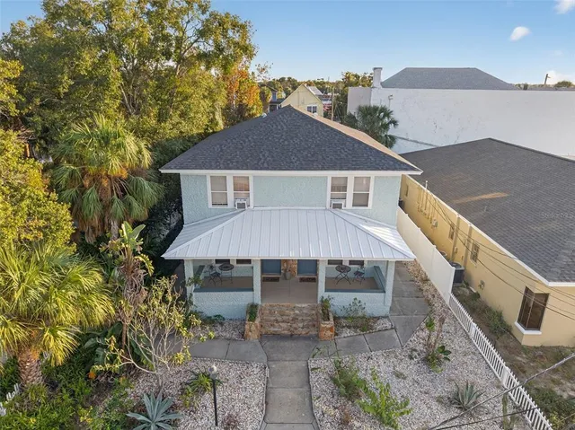 a front view of house with yard and trees in the background
