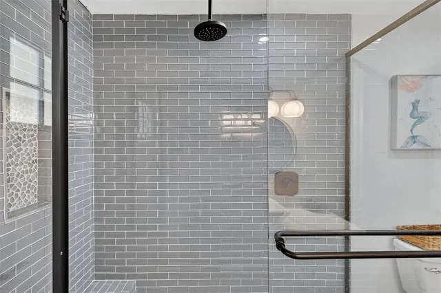 a view of a white house with large windows and wooden fence