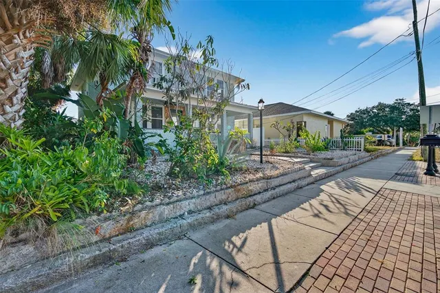 a front view of a house with a yard and potted plants