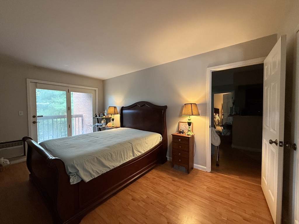 4975 Washington Street, Unit 305 Boston, MA 02132 - Photo 11 of 13 a bedroom with a bed and a large window