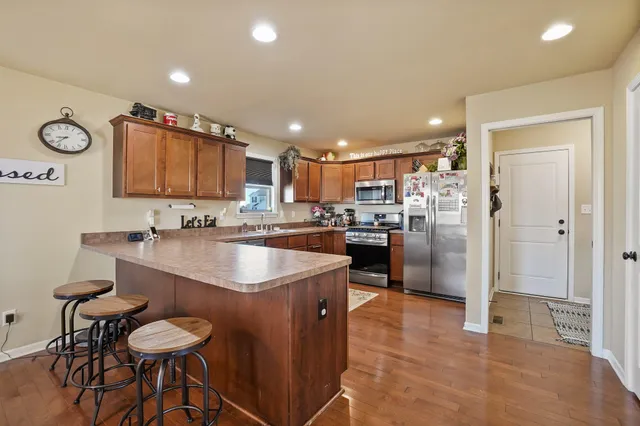 a kitchen with stainless steel appliances granite countertop a sink and a refrigerator
