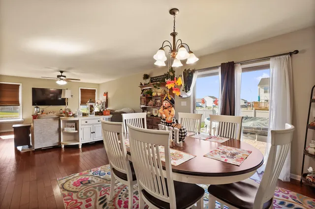 a view of a dining room with furniture a chandelier and wooden floor