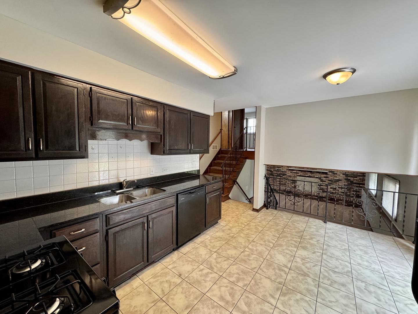17945 Maple Street Lansing, IL 60438 - Photo 16 of 33 a kitchen with stainless steel appliances a sink dishwasher stove and cabinets
