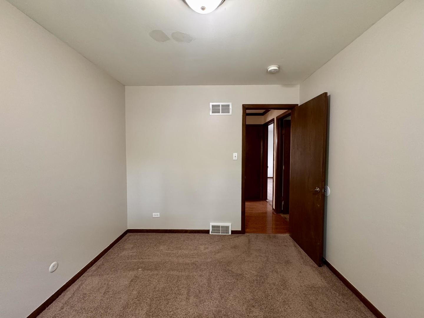 17945 Maple Street Lansing, IL 60438 - Photo 23 of 33 an empty room with closet and wooden door