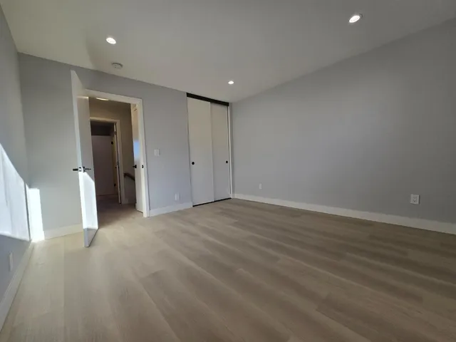 a view of a big room with wooden floor and windows