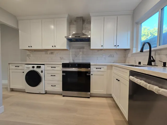 a kitchen with a stove top oven sink and a window