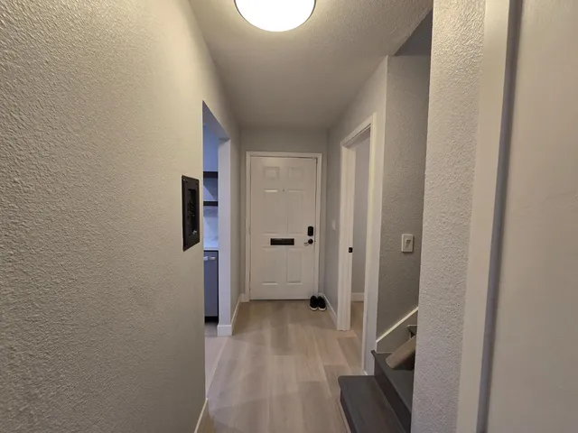 a view of a hallway with wooden floor and closet