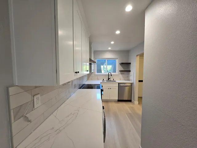 a room with a bed and a view of kitchen