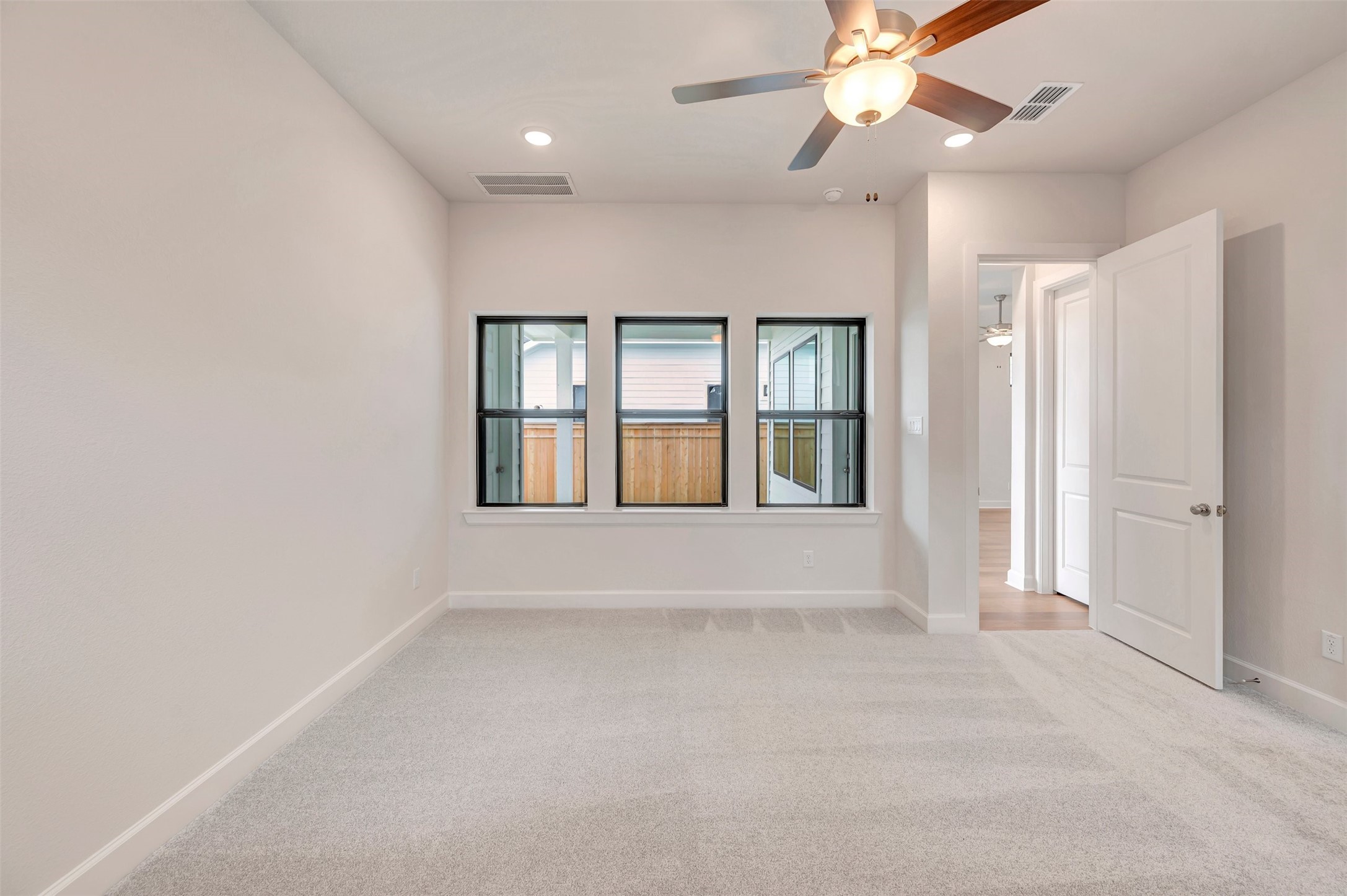 2718 Cottage Place Rosharon, TX 77583 - Photo 32 of 50 an empty room with chandelier fan and windows