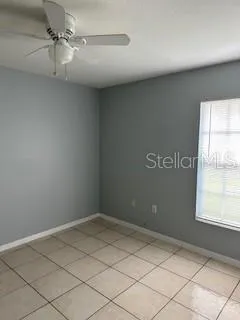 an empty room with windows and fan