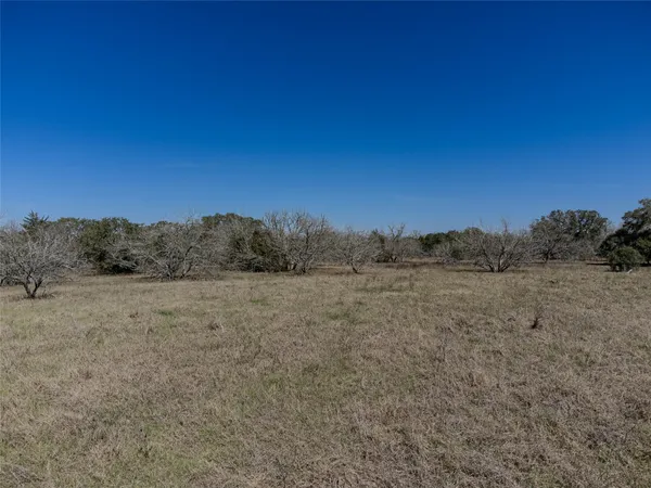 a view of a field with a building in the background