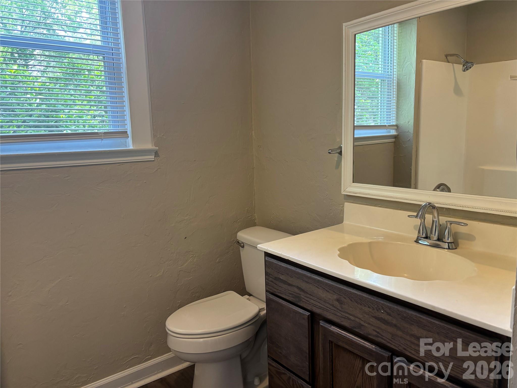 975 Old Charlotte Road Southwest Concord, NC 28027 - Photo 7 of 28 a bathroom with a sink a toilet and a window