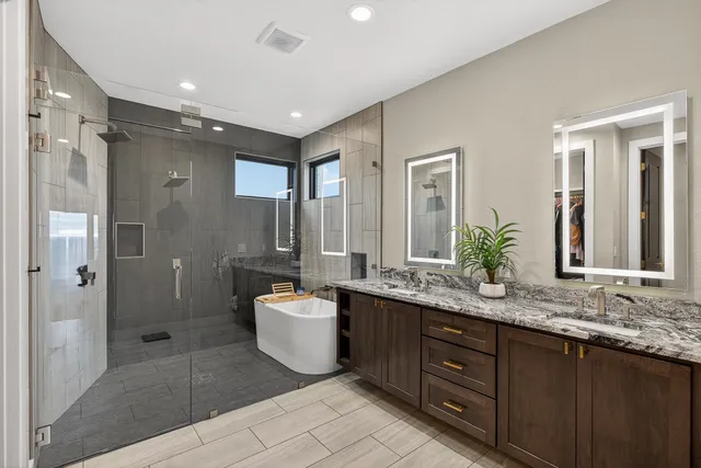 a spacious bathroom with a bathtub shower sink double and mirror