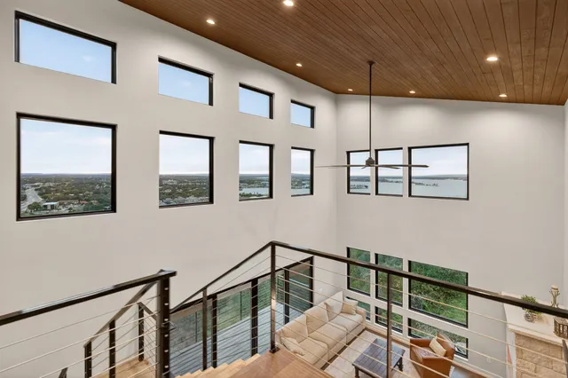 a view of staircase with lots of frames on wall and a window