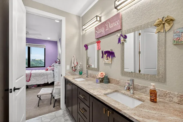 a en suite bathroom with a granite countertop sink and a mirror