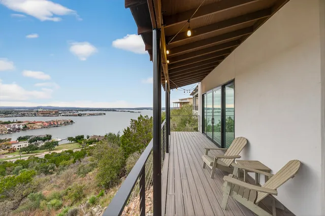 a balcony with wooden floor and outdoor seating
