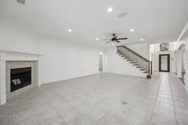 an empty room with a ceiling fan and windows