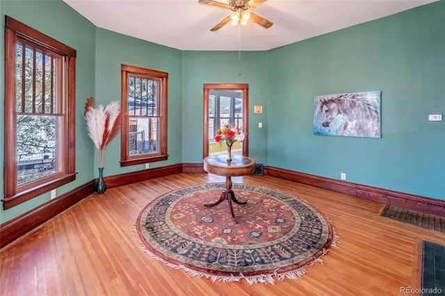 a room with lots of frames on wall and wooden floor