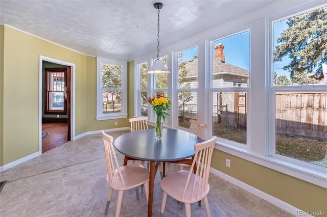 a dining room with furniture a chandelier and wooden floor