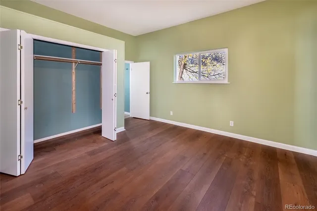 an empty room with wooden floor and closet
