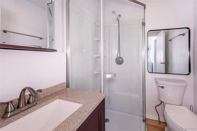 a bathroom with a granite countertop sink toilet and shower