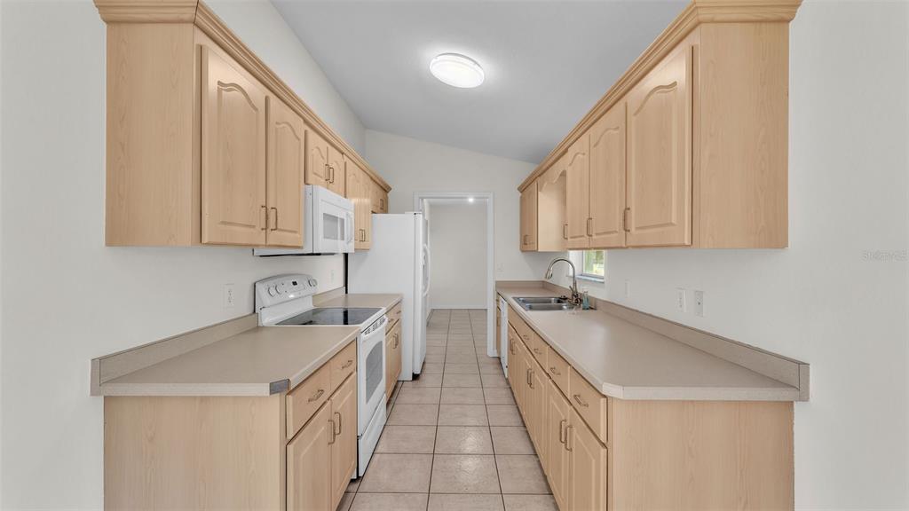 4515 Starfish Avenue Sebring, FL 33870 - Photo 18 of 38 a kitchen with a sink a stove and cabinets