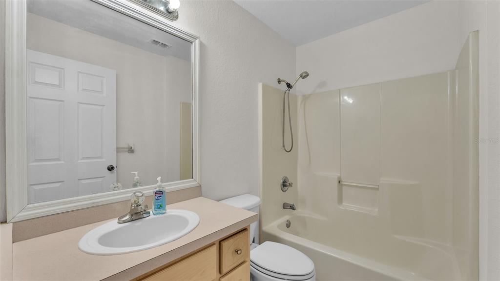 4515 Starfish Avenue Sebring, FL 33870 - Photo 27 of 38 a bathroom with a granite countertop sink toilet a mirror and shower
